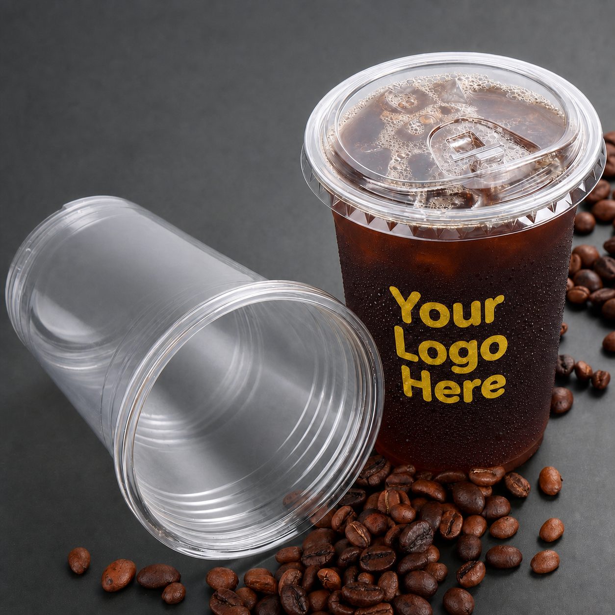 Clear cold cup with custom logo printing next to coffee beans